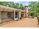 Backyard deck and patio area with a stone fireplace providing seamless indoor-outdoor living at 19620 Fox Trl, Dunnellon, FL 34432