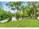 Expansive backyard overlooking the tranquil lake, complete with dock access, and mature trees at 19620 Fox Trl, Dunnellon, FL 34432