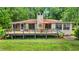Lovely back of house with wooden deck and stone chimney, perfect for outdoor relaxation at 19620 Fox Trl, Dunnellon, FL 34432