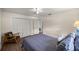 Comfortable bedroom featuring wood floors, ceiling fan, and a cozy chair at 19620 Fox Trl, Dunnellon, FL 34432