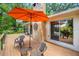 Outdoor deck with umbrella, seating, and a stone fireplace providing serene riverside views at 19620 Fox Trl, Dunnellon, FL 34432