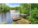 Picturesque dock with bench seating and covered area, overlooking the tranquil lake at 19620 Fox Trl, Dunnellon, FL 34432