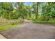 Long private driveway leading to the property, lined with mature trees and lush greenery at 19620 Fox Trl, Dunnellon, FL 34432
