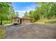 Exterior showing attached storage building with roll up garage door, concrete drive and landscaping at 19620 Fox Trl, Dunnellon, FL 34432
