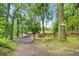Serene setting of home among mature trees, with a winding driveway, and view of the lake at 19620 Fox Trl, Dunnellon, FL 34432
