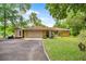 Beautiful home exterior showcasing stone details, mature landscaping, and an attached garage at 19620 Fox Trl, Dunnellon, FL 34432