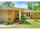 Charming home exterior featuring stone accents, lush landscaping, and a welcoming front porch at 19620 Fox Trl, Dunnellon, FL 34432