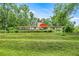 Home's rear exterior boasts a large deck with seating, stone chimney, and lush landscaping at 19620 Fox Trl, Dunnellon, FL 34432