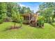 Charming home featuring a screened in porch and a staircase leading down to the lush green yard at 19620 Fox Trl, Dunnellon, FL 34432