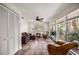 Bright sunroom with tile flooring, comfortable seating, and large windows showcasing water views at 19620 Fox Trl, Dunnellon, FL 34432