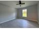 Bedroom with a ceiling fan and window overlooking green grass at 19990 Sw 75Th St, Dunnellon, FL 34431