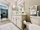 Well-lit bathroom with white cabinets, tile floor, and a view into the main bedroom at 2100 Nw 50Th Cir, Ocala, FL 34482