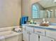 Bathroom featuring and sinks, bath towels, and a garden tub and shower with a glass block window at 2100 Nw 50Th Cir, Ocala, FL 34482