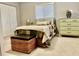 Bedroom featuring a double bed, a wooden foot locker, a dresser, and a white venetian blind at 2100 Nw 50Th Cir, Ocala, FL 34482