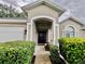 Inviting front porch area with a charming black door and decorative wreath at 2100 Nw 50Th Cir, Ocala, FL 34482