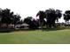 Scenic golf course view with a well-manicured green, surrounded by lush trees and a peaceful community setting at 2100 Nw 50Th Cir, Ocala, FL 34482