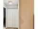 Hallway featuring a modern light fixture and a closet with a white folding door and neutral colored walls at 2100 Nw 50Th Cir, Ocala, FL 34482