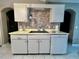 Kitchen sink and dishwasher with brick-like backsplash and white cabinets in a modern-style space at 2100 Nw 50Th Cir, Ocala, FL 34482