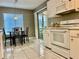 Bright kitchen features white cabinets, tile flooring, and adjacent dining area with sliding door at 2100 Nw 50Th Cir, Ocala, FL 34482