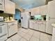 White kitchen features tiled flooring, bright cabinets, and modern appliances for a fresh, clean feel at 2100 Nw 50Th Cir, Ocala, FL 34482