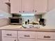 Bright kitchen countertop with stainless steel toaster oven, coffee maker, and white cabinetry at 2100 Nw 50Th Cir, Ocala, FL 34482