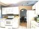 Cozy kitchen with white cabinets and appliances with archway into breakfast nook at 2100 Nw 50Th Cir, Ocala, FL 34482