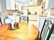 Spacious kitchen featuring white cabinets and appliances with an adjacent breakfast nook with wooden table at 2100 Nw 50Th Cir, Ocala, FL 34482