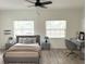 Digitally staged bedroom with bright windows, ceiling fan, neutral walls, wood floors, and neutral color scheme at 21111 Sw Honeysuckle St, Dunnellon, FL 34431