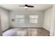 Bright room with modern floors, neutral walls, ceiling fan, and natural light streaming through two windows at 21111 Sw Honeysuckle St, Dunnellon, FL 34431