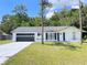 Charming single-story home featuring a well-maintained lawn and a spacious two-car garage at 21111 Sw Honeysuckle St, Dunnellon, FL 34431