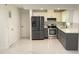 Modern kitchen featuring stainless steel appliances and gray cabinets with white marble countertops at 21111 Sw Honeysuckle St, Dunnellon, FL 34431