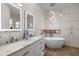 Bathroom with marble tiled walls, soaking tub and decorative hanging lights at 2418 Se 22Nd Pl, Ocala, FL 34471