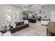 Open-concept living room with kitchen view, hardwood floors, and cozy leather sofa seating at 2418 Se 22Nd Pl, Ocala, FL 34471