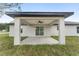 Covered patio with a ceiling fan offers an outdoor space for relaxation with a view of the grassy backyard at 26 Water Track Dr, Ocala, FL 34472