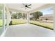 Spacious covered back porch offers a ceiling fan and overlooks a large, well-maintained backyard with mature trees at 26 Water Track Dr, Ocala, FL 34472