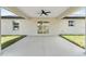 Rear patio showcases a large concrete space with a ceiling fan and sliding glass doors, perfect for enjoying the outdoors at 26 Water Track Dr, Ocala, FL 34472