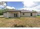Expansive backyard featuring a covered patio with a sliding glass door, perfect for outdoor living and entertaining at 26 Water Track Dr, Ocala, FL 34472