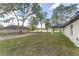 Expansive backyard featuring a covered patio, lush green grass, and mature trees, perfect for outdoor living at 26 Water Track Dr, Ocala, FL 34472