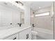 Modern bathroom featuring a marble countertop vanity, sleek fixtures, and bright, neutral-toned tile in the shower and walls at 26 Water Track Dr, Ocala, FL 34472