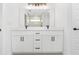 Modern bathroom featuring double vanity, a large mirror, and white cabinets with matte black hardware at 26 Water Track Dr, Ocala, FL 34472
