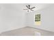 Simple bedroom featuring neutral tile flooring, a window with a view, and a modern ceiling fan at 26 Water Track Dr, Ocala, FL 34472