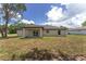 Rear exterior view showcasing the covered patio and seamless access to the backyard with sliding glass doors at 26 Water Track Dr, Ocala, FL 34472
