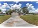 Lovely one-story home with a long driveway, green lawn, and attached two-car garage at 26 Water Track Dr, Ocala, FL 34472