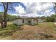 Home exterior with a covered patio, complemented by a well-maintained lawn and clear blue sky at 26 Water Track Dr, Ocala, FL 34472