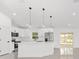 Bright kitchen features white cabinets, stainless steel appliances, and a large island with pendant lighting at 26 Water Track Dr, Ocala, FL 34472