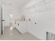 Bright laundry room boasts ample counter space, a convenient sink, and a wire rack for storage, adjacent to a well-lit hallway at 26 Water Track Dr, Ocala, FL 34472