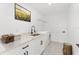 Well-lit laundry room with white cabinetry, light countertops, black hardware, and front-loading washer and dryer at 26 Water Track Dr, Ocala, FL 34472