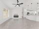 Bright living room featuring a modern fireplace, ceiling fan, and gleaming tile floors at 26 Water Track Dr, Ocala, FL 34472