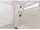 Modern shower with white marble tile, black trim, a built-in niche, window and sleek black shower fixtures at 26 Water Track Dr, Ocala, FL 34472