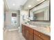 Bathroom featuring granite counters, warm cabinetry and a large framed mirror above the vanity at 2908 Se 22Nd Ave, Ocala, FL 34471
